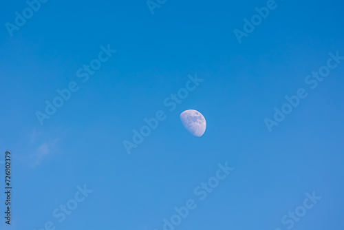 Natural phenomenon, Half moon in daytime with blue clear sky, A completely normal occurrence in astronomy is that the moon is directly opposite the sun in the sky, Nature background.