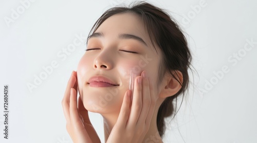 A woman cleaning her face with her hands on a white background