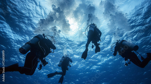 A group of divers dressed in full wetsuits and equipped with safety harnesses descend into the deep blue waters for an important underwater repair job.