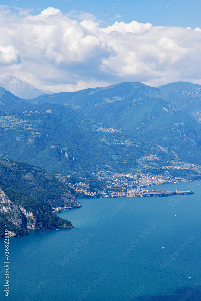 Mountain landscape, picturesque mountain lake in the summer morning, large panorama, landscape with fabulous lake view from the top of the mountain, with view of city. Iseo, Italy