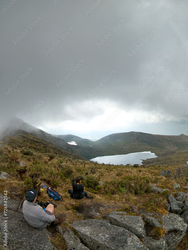 View of Chingaza Paramo, tourists resting after a day of hiking, surrounded by frailejones, mountains, lakes, plants and animals