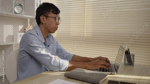 Man using laptop to work on table in office, Press the keyboard on the laptop, Remote work.