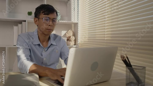 Man using laptop to work on table in office, Press the keyboard on the laptop, Remote work.