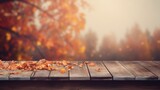 a wooden table with a blurred autumn background and a place for text.