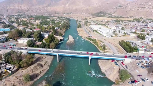 An aerial shot of two bridges crossing a river in a village, with cars crossing the bridge. The location is Faizabad, Badakhshan, Afghanistan. photo