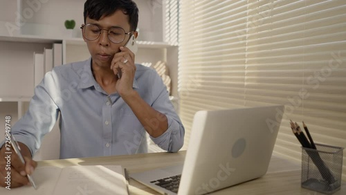 Man talking on the phone in the office, Take notes during conversations, Remote work of business people.