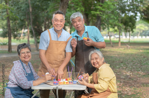 Asian elderly group Do activities together in public parks coloring potted plants Smile happily in retirement