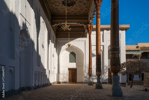 View of the courtyard of the Bahauddin Naqshbandi Memorial Complex and the entrance to the Amir Muzaffarkhan Mosque on a sunny day, Bukhara, Uzbekistan photo