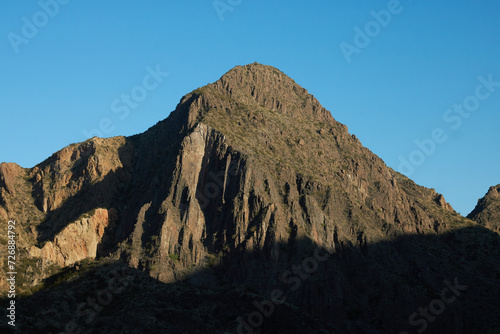 view of the top of a mountain with a harsh contrast by sunlight