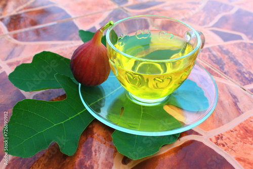 Cozy herbal organic linden tea in teapot and cup of tea. Dry fragrant flowers, autumn arrangements, figs, peaches and book. Cozy atmosperic home photo