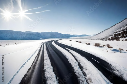 Black asphalt road winding through winter snow white landscape © MISHAL