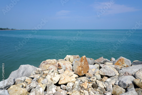 The sea is bordered by large breakwater rocks. sea and rock background. Breaking sea waves on the beach. sea view background concept
 photo