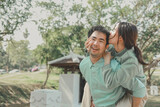 A young couple is walking around in nature, lovely couple smiling under the sunlight, Happy couple in love spending time outdoors, Portrait of a cheerful couple is hugging each other in the park.