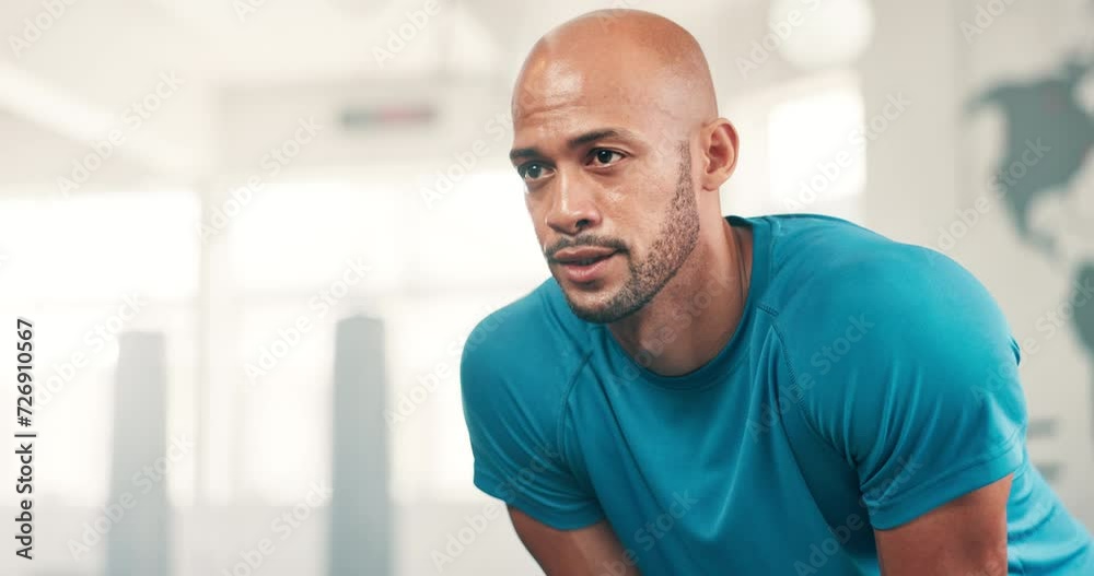 Exercise, tired and breathing with man in gym to rest from workout for health or cardio. Face, sweating and intensity with exhausted young athlete training for fitness, performance or improvement Exercise, tired and breathing with man in gym to rest from workout for health or cardio. Face, sweating and intensity with exhausted young athlete training for fitness, performance or improvement