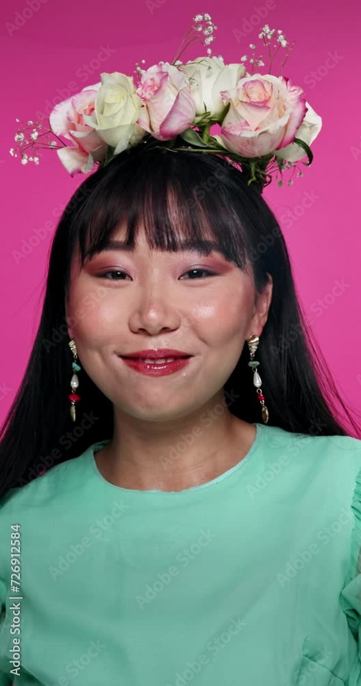 Face, flowers and Japanese woman with makeup, fashion and shine on a pink studio background. Portrait, person and model with plants and natural beauty with stylish outfit and confident girl with glow Face, flowers and Japanese woman with makeup, fashion and shine on a pink studio background. Portrait, person and model with plants and natural beauty with stylish outfit and confident girl with glow