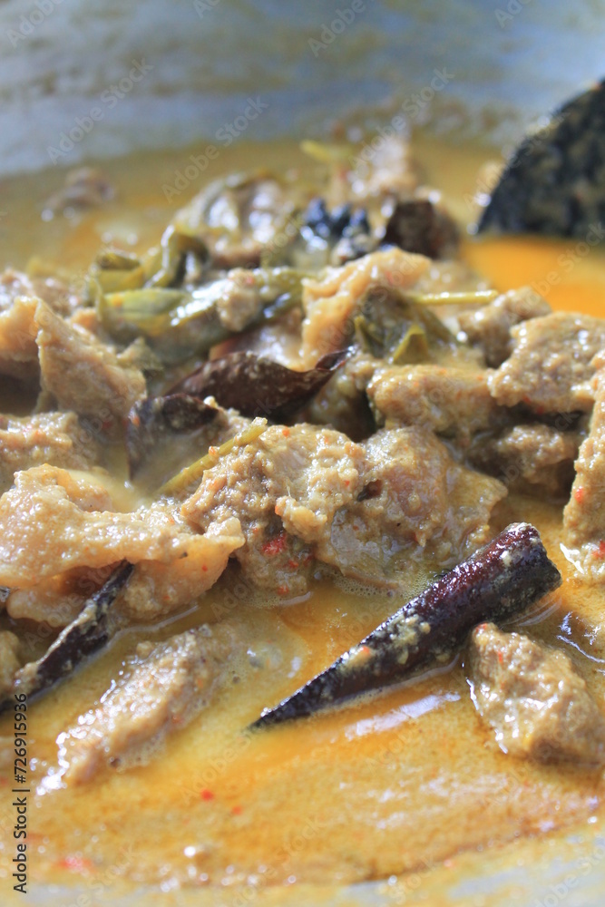 The process of cooking rendang in a traditional stove uses charcoal The process of cooking rendang in a traditional stove uses charcoal