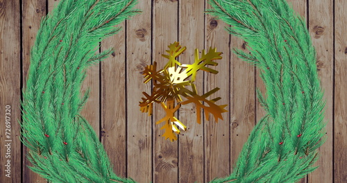 Image of gold snowflake christmas decoration and green branches on wooden background