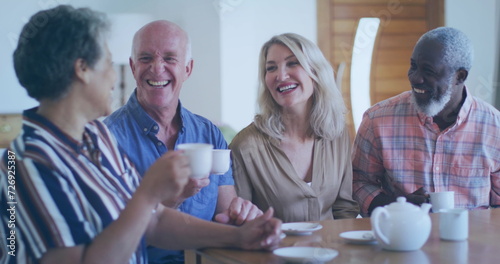 Konstfotografi Diverse group of friends share laughter over coffee at home