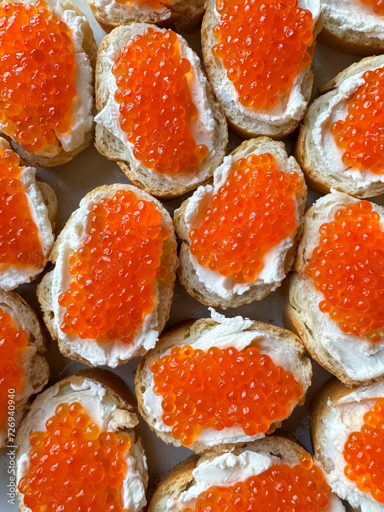 Baguette sandwiches with red salmon caviar and cheese. Top view.