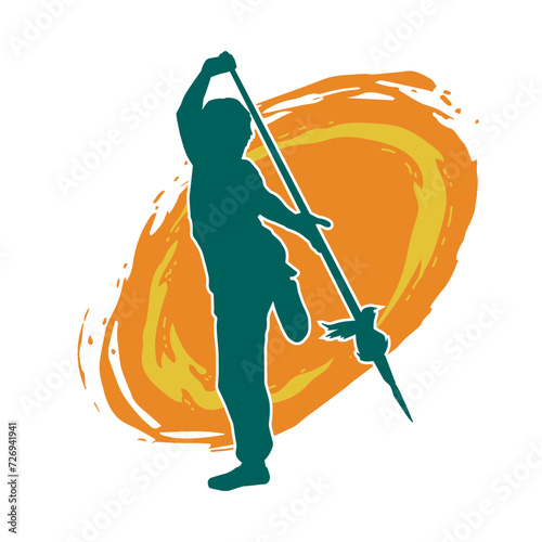 Silhouette of a wushu martial artist in action pose with a spear weapon. Silhouette of a fighter carrying a spear weapon.