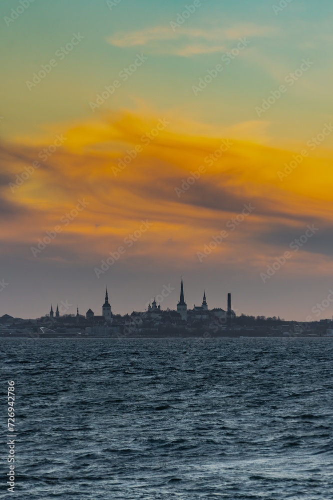 Naklejka premium Tallinn old town city skyline with orange sunset clouds in winter