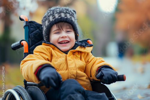 happy boy using wheelchair laughing in winter jacket and hat outside