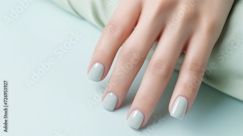 Glamour woman hand with mint green nail polish on her fingernails. Green nail manicure with gel polish at luxury beauty salon. Nail art and design. Female hand model. French manicure. 