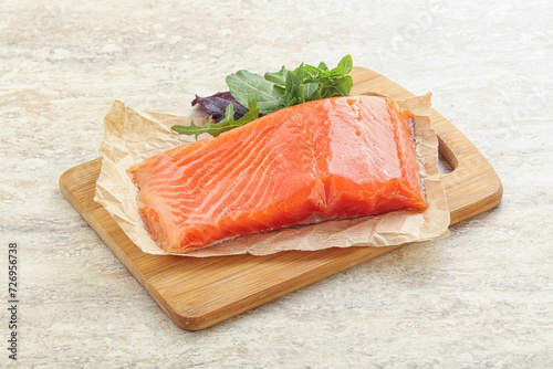 Raw salmon fillet over board