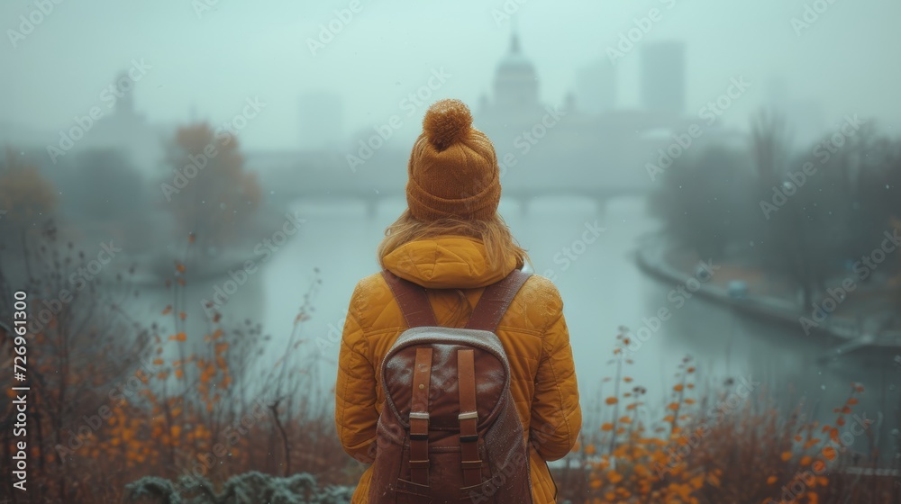 A girl in a yellow jacket with a backpack stands on the bank of the river and looks at the city. - Generative AI A girl in a yellow jacket with a backpack stands on the bank of the river and looks at the city. - Generative AI