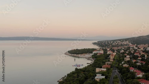 The quiet coastline of Novi Vinodolski in Croatia during sunrise, breathtaking sea view, golden hour, early morning view of the calm Adriatic sea, tourism, travel destination, summer holiday adventure photo