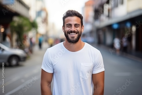 Portrait of a handsome young man smiling at the camera in the city
