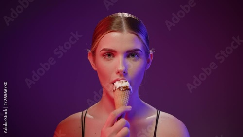 Caucasian woman with studio background eats an ice cream suggestively close shot photo