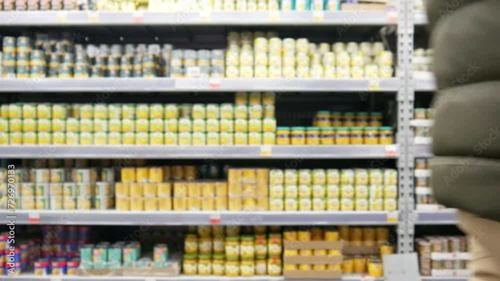 Close-up of a shopping trolley in a grocery store and a male buyer picks it up and rolls it Close-up of a shopping trolley in a grocery store and a male buyer picks it up and rolls it