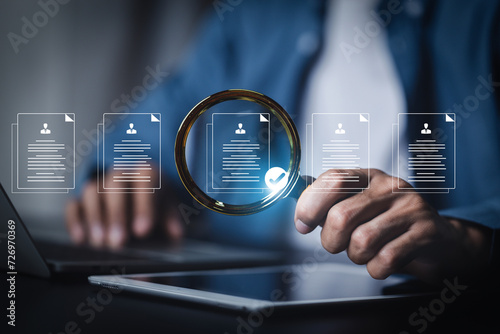 Management concept. , Businessman use magnifying glass focus to human icons for customer focus group. Data exchanges development and customer service , Customer relationship . photo