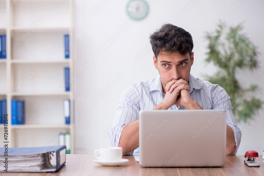 Young male employee working in the office Young male employee working in the office