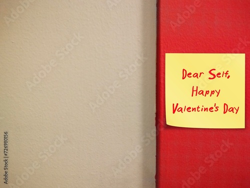 Note paper stick on red copy space wall with handwritten text DEAR SELF - HAPPY VALENTINE'S DAY - concept of self-love, single person give themselves love and care message on Valentine's photo