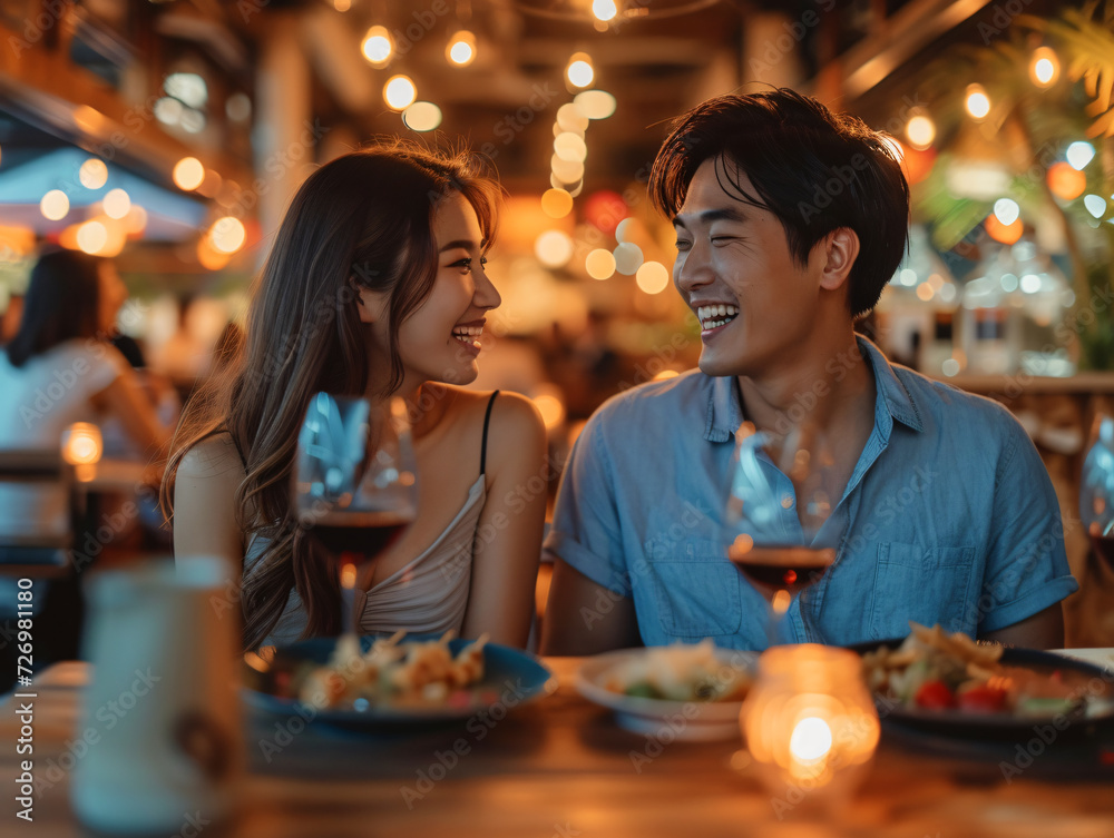 A man and woman smile at each other across a restaurant table having a luxury dinner