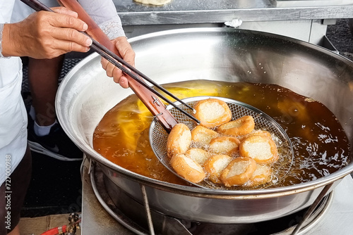 Hawker scooping out cooked Ham Chim Peng from wok, a popular Chinese street food in Malaysia