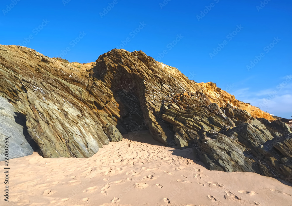 Obraz premium Colorful slate natural rocks at the beach of Vila Nova de Milfontes in Portugal