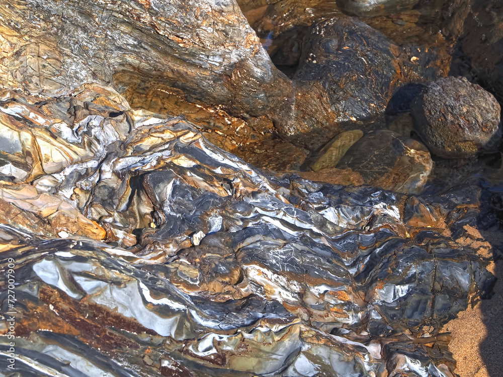 Colorful slate natural rocks at the beach of Vila Nova de Milfontes in Portugal