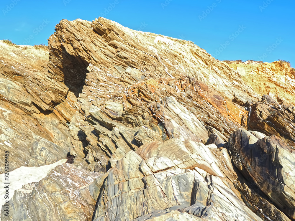 Colorful slate natural rocks at the beach of Vila Nova de Milfontes in Portugal