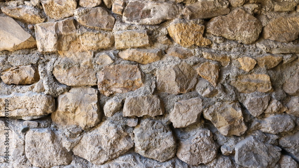 The use of natural stone in the design of the exterior, cobblestones in cement concrete as part of the exterior wall, stone texture of a fragment of an old wall or fence The use of natural stone in the design of the exterior, cobblestones in cement concrete as part of the exterior wall, stone texture of a fragment of an old wall or fence