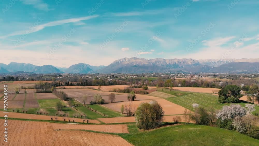 Solitary road in the middle of fields and small village. Cinematic video of italian countryside with fields and nature in spring with colorful trees. Drone video with fields and nature with alps mount Solitary road in the middle of fields and small village. Cinematic video of italian countryside with fields and nature in spring with colorful trees. Drone video with fields and nature with alps mount