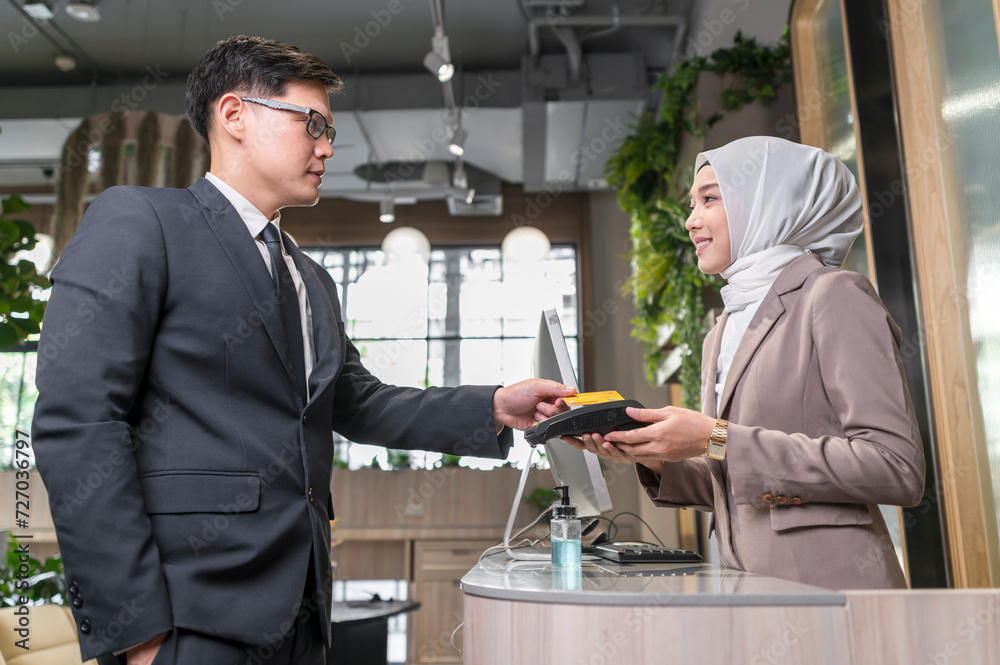 Customer used wireless credit card at cashier restaurant counter with smily service - financial technology and cashless concept