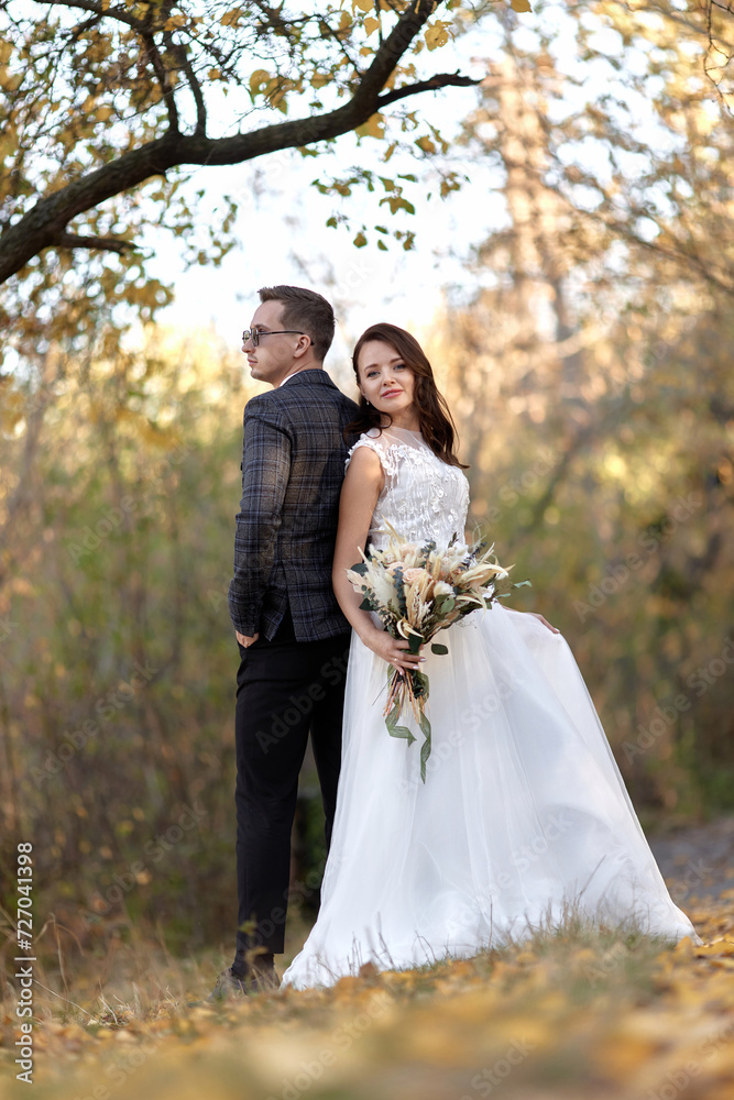 beautiful sensual bride in white wedding dress and groom standing outdoor on natural background beautiful sensual bride in white wedding dress and groom standing outdoor on natural background