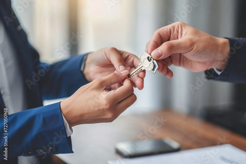 Real estate agent giving the keys from the new house to its owners.New home buying concept