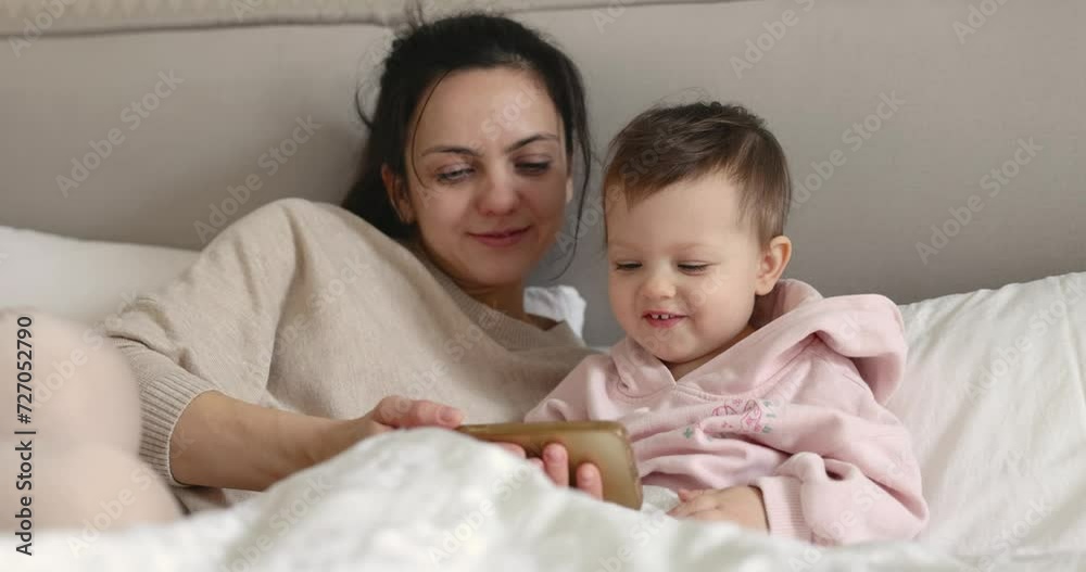 Caucasian mother and child enjoying using smart phone at home Caucasian mother and child enjoying using smart phone at home