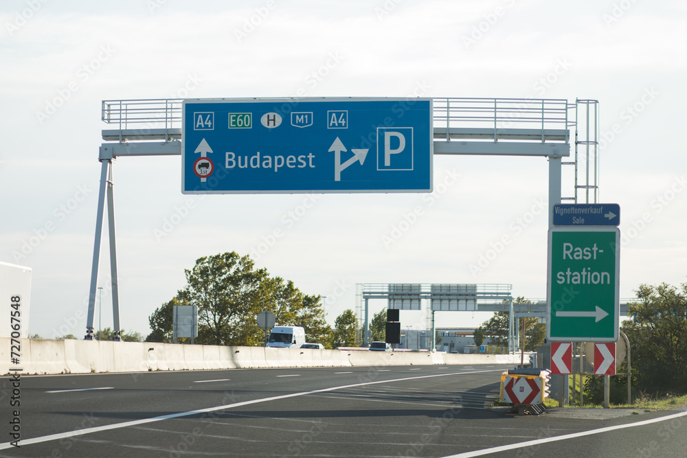 Road signs on the highway. Long road to the capital of Hungary, Budapest. Road to Budapest. Road signs with the route number, parking and direction to the city.