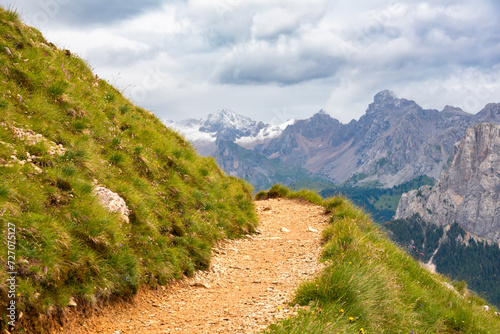 Mountain hiking trail with people walking in Dolomite alps