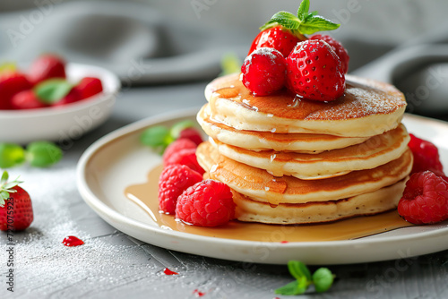 delicious stack of golden pancakes with maple syrup and banana berry on a plate in bed for breakfast room service cozy scandinavian food cafe in editorial magazine studio setting natural light